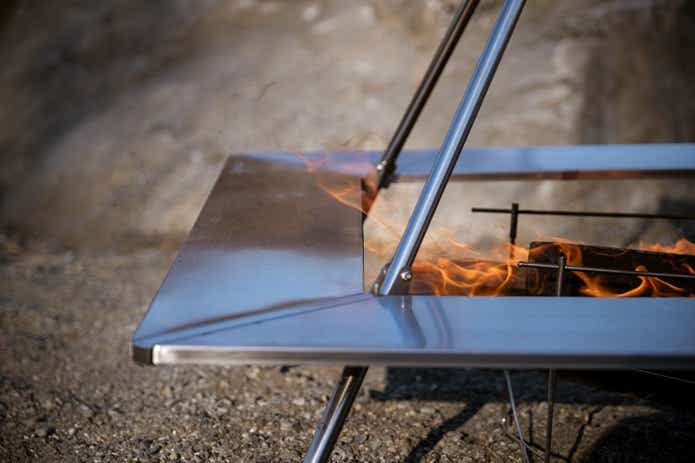 「ピコグリル760」を設置したテンマクデザイン「ウッドストーブテーブル」 風の影響で一部の天板に炎が襲いかかる様子