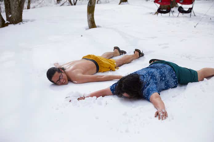 テントサウナから出て雪に寝転ぶ男性二人