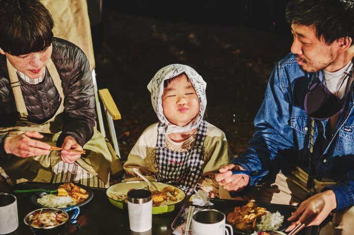 キャンプで料理を食べる親子
