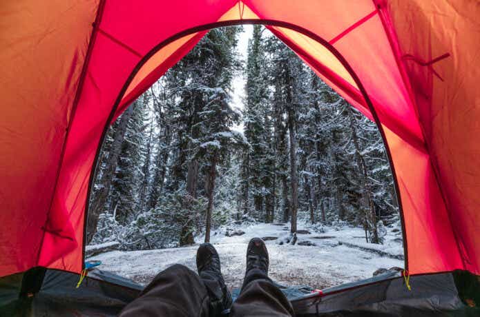 冬キャンプでテントの中で寝る人