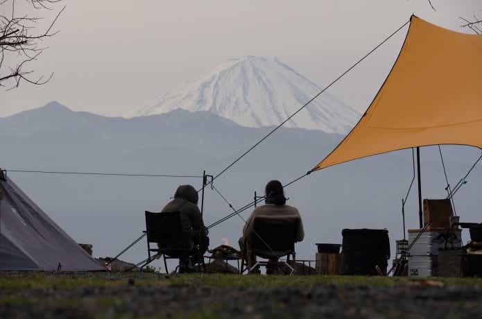 富士山を眺めながら冬キャンプを楽しむ二人組