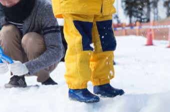 スノーブーツを履いて雪の上を歩く子供