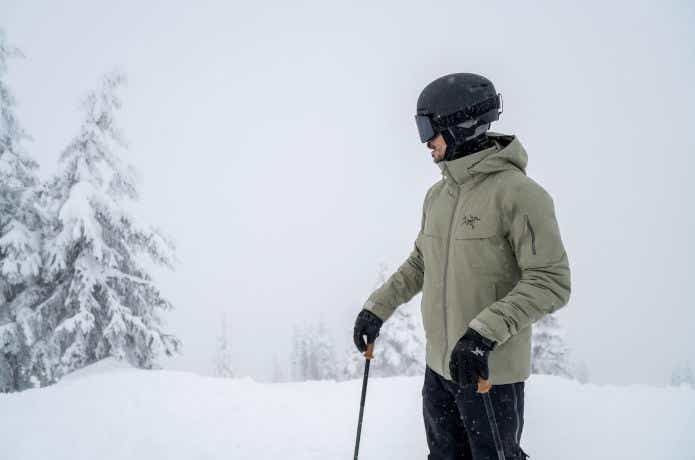 アークテリクスのジャケットを着て雪山を歩く男性