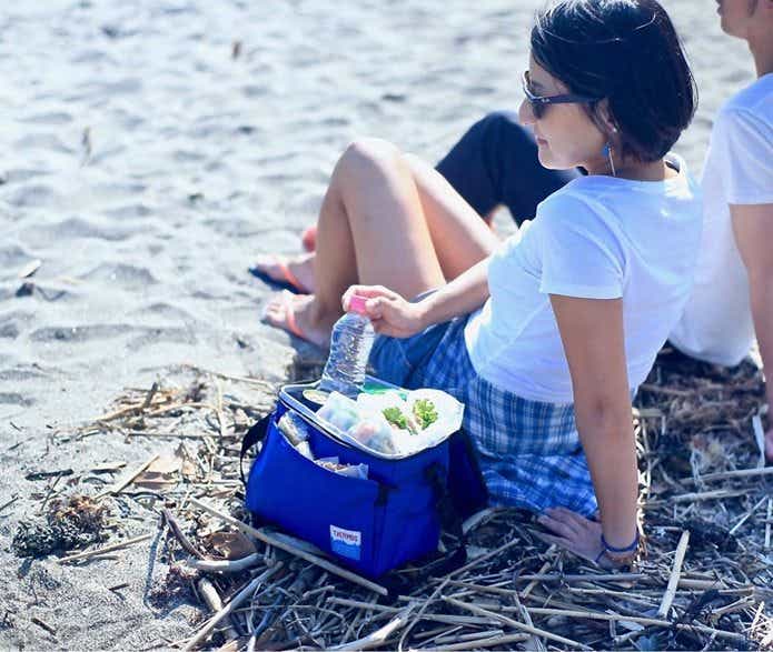 サーモス保冷バッグを使って砂浜でくつろぐ女性