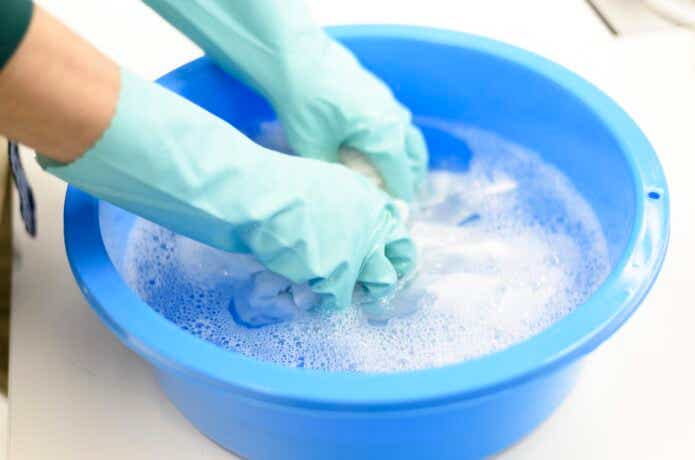 青いバケツに水を張って保冷バッグを手洗いしている