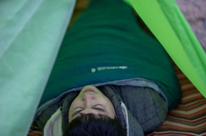 テントの中で寝る男性