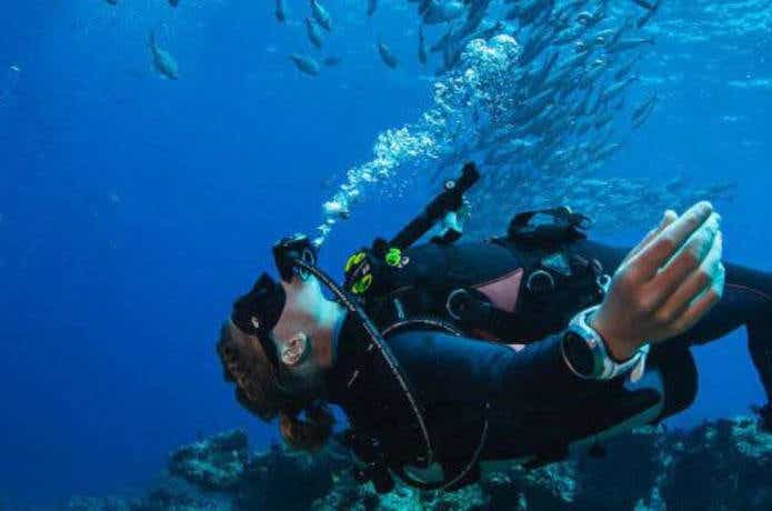 スントの防水腕時計をつけてスキューバダイビングをする男性