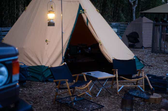 ランタンで照らされたキャンプサイトに建つおしゃれなワンポールテント