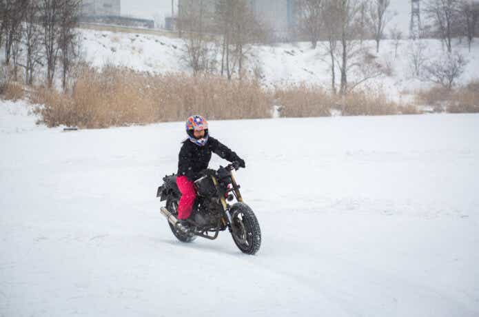 バイクで雪道を走る女性