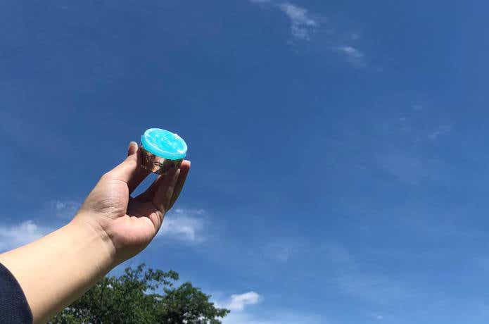 固形燃料を青空に掲げている人