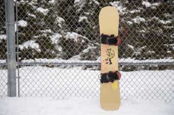 フェンスに立て掛けられたスノーボードの板