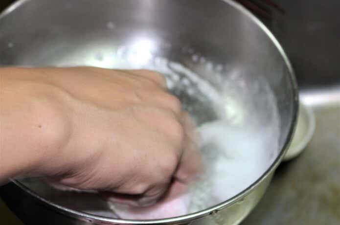食器用洗剤で鍋を洗う男性の手