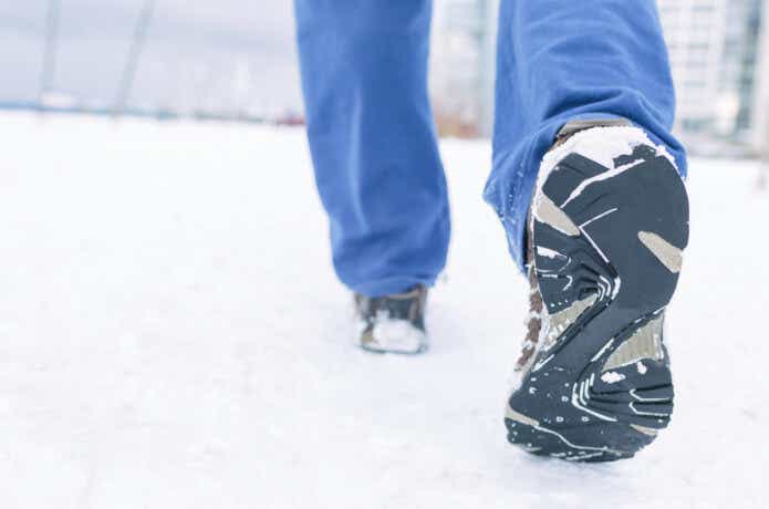冬に防水スニーカーを履いて雪道を歩く人