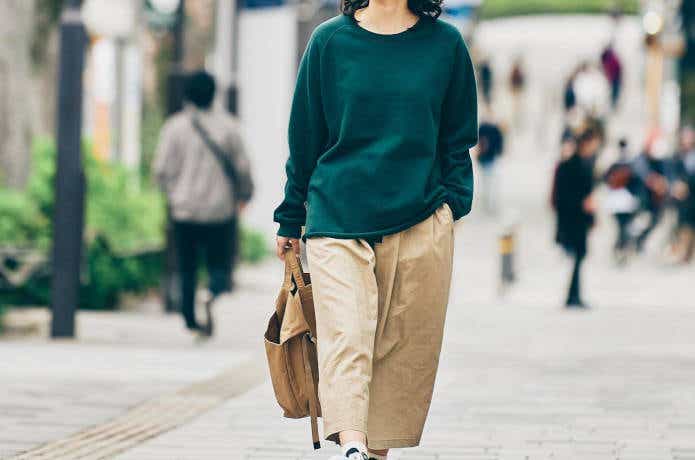アウトドア風ファッションで街を歩く女性