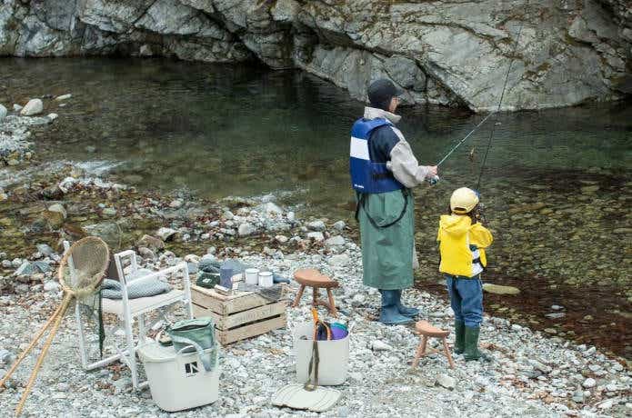 川で釣りをする親子