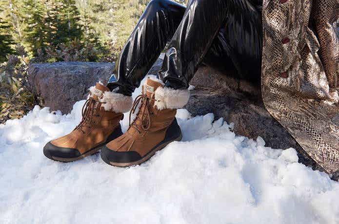 雪の上にスノーブーツを履いた足を置く