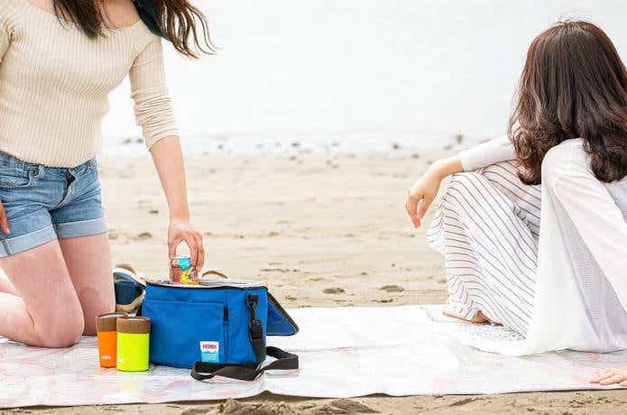 保冷バッグを持って砂浜ピクニック