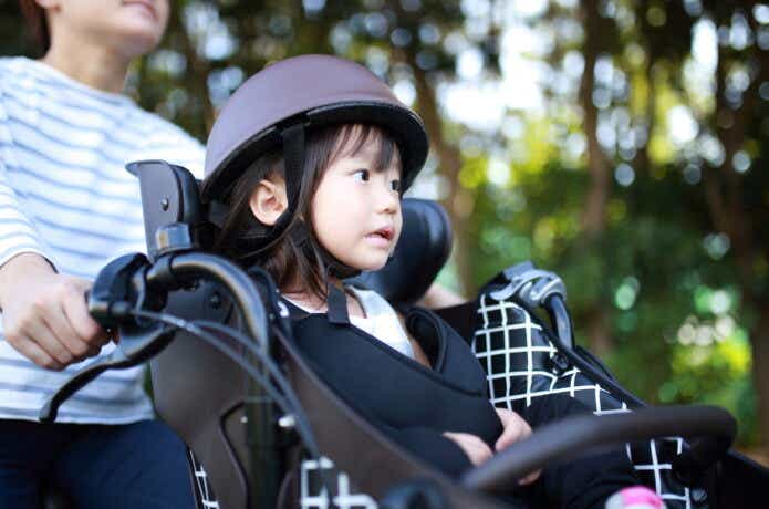前乗せタイプのチャイルドシート付き電動アシスト自転車に乗る子ども