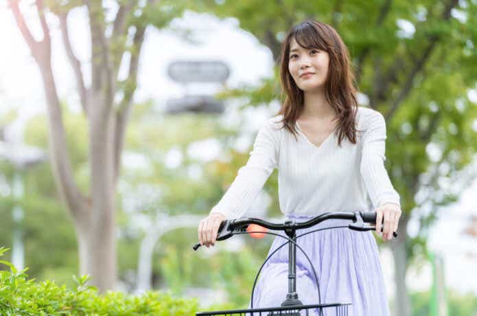 電動アシスト自転車に乗って街中を走る女性