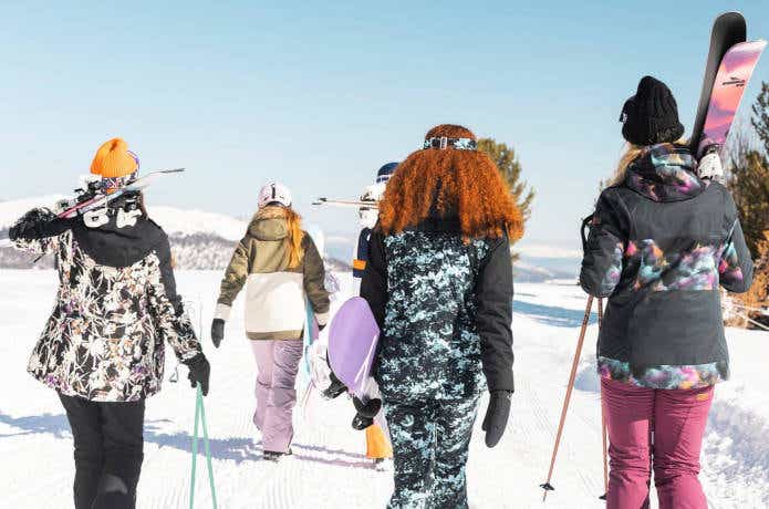 スノーボードウェアを着てゲレンデに向かう女性たち