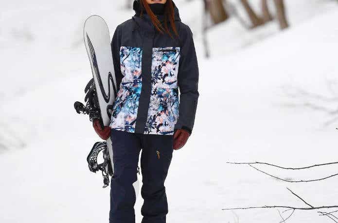 雪山に佇む女性スノーボーダー