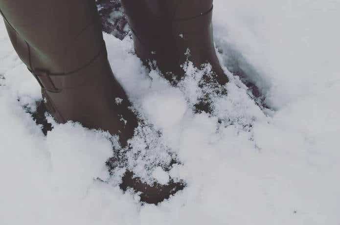 雪に足先が埋もれている防寒長靴