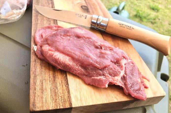 生の牛肉とオピネルナイフ