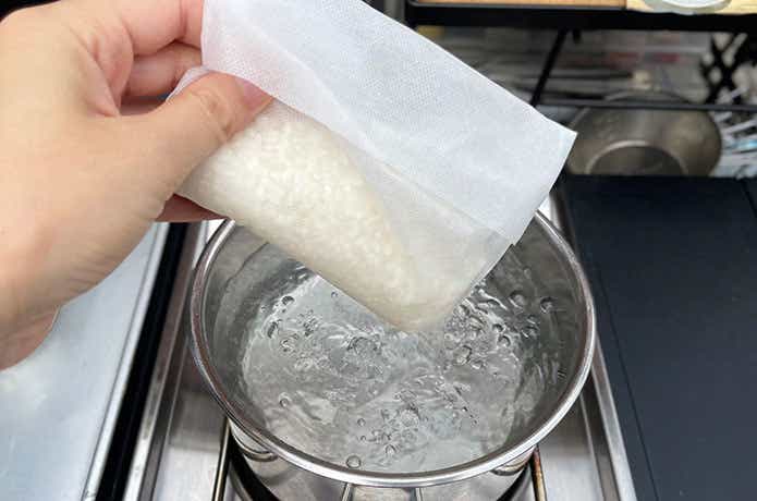 ダイソー「炊飯袋」に米を入れて沸騰しているお湯に投入するシーン_撮影筆者