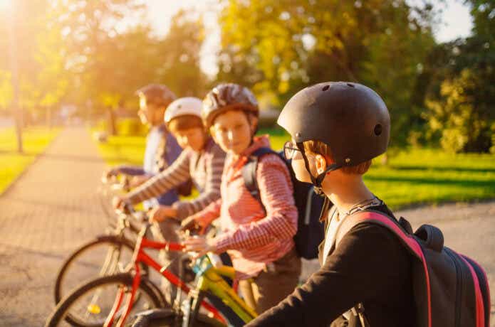 ヘルメットを被ってジュニア向け自転車に乗る子どもたち