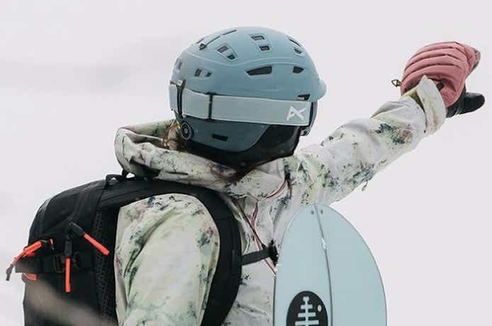 ベンチレーション付きのスノーボード用ヘルメットをかぶる人