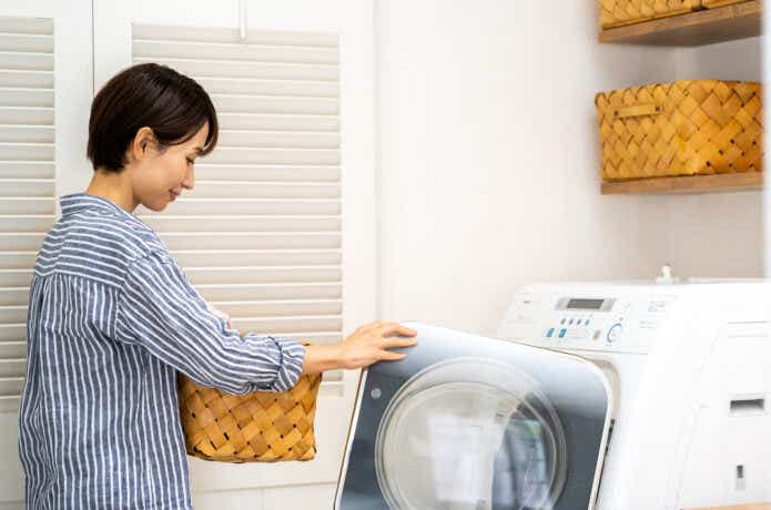 洗濯機に衣類を入れる女性
