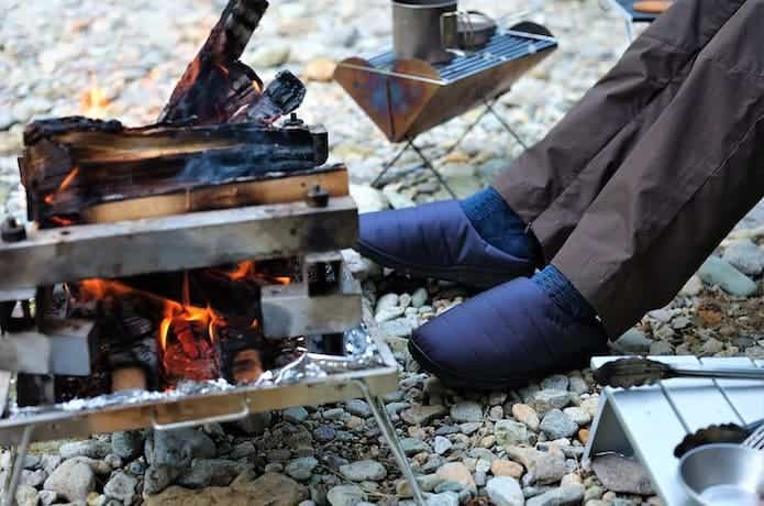 難燃性素材を採用した靴を履きながら焚き火をしている
