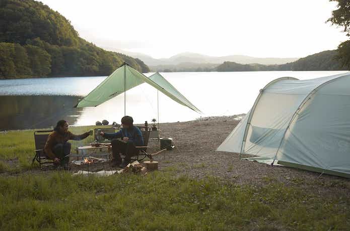湖畔でキャンプをする二人