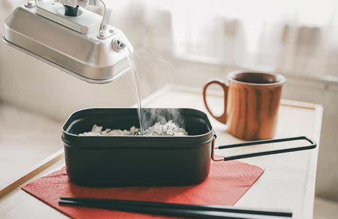 コンパクトな手のひらサイズのケトルでお茶漬け食材にお湯を注ぐところ。