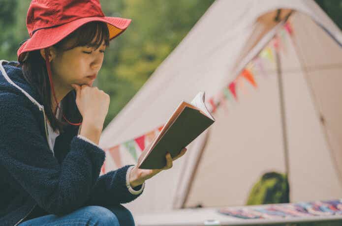 キャンプで読書中の女性