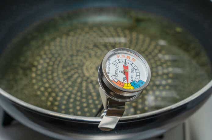 揚げ鍋に入った油を温度計で計測中