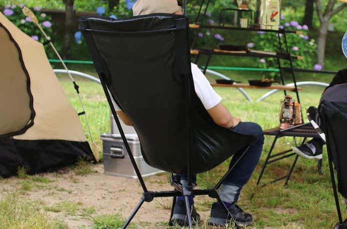キャンプで黒い椅子に座る人