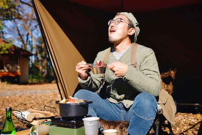 キャンプでおでんを食べる男性