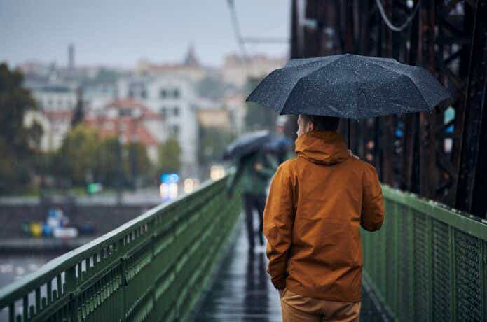 雨の日に街を歩いている男性。