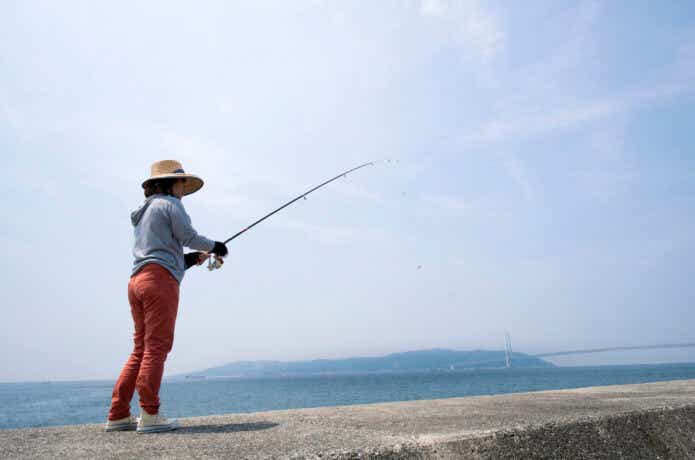 防波堤で釣りをしている女性。