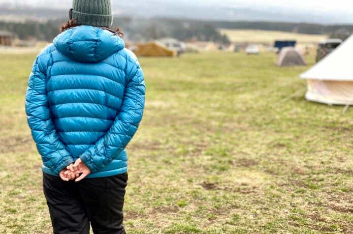 ダウンジャケットを着て冬にソロキャンプをしている女性。