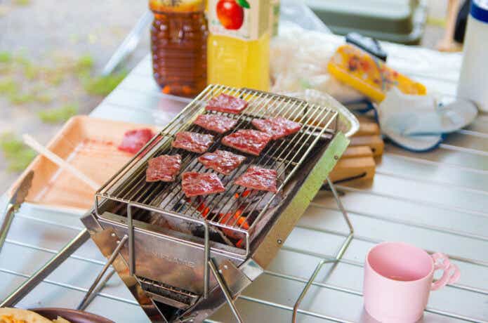 屋外向きの卓上コンロで焼肉をしている