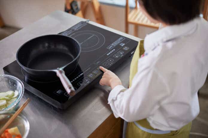 IH調理器を操作している女性