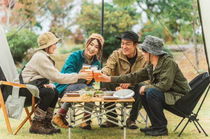 キャンプ場で乾杯する大人