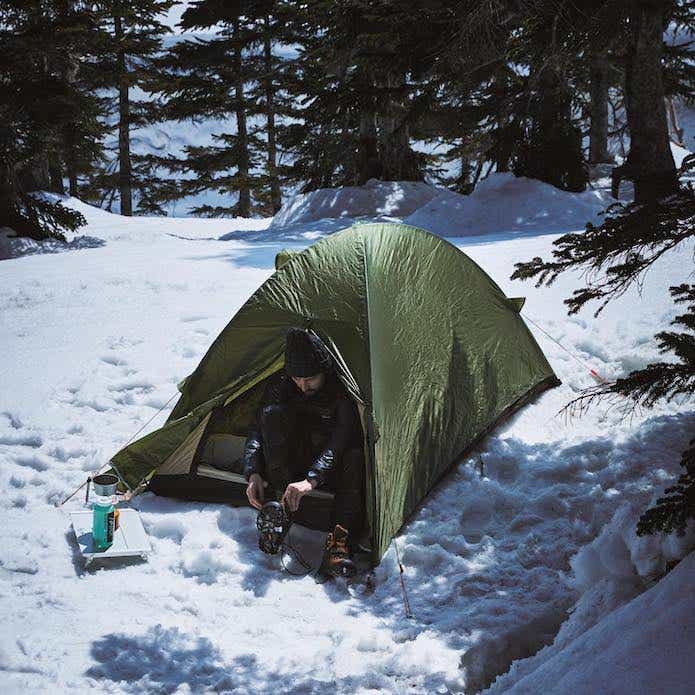 雪山でテント泊をしている男性