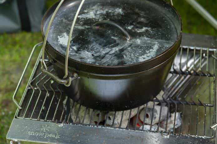 網の上に置かれた焦げたダッチオーブン