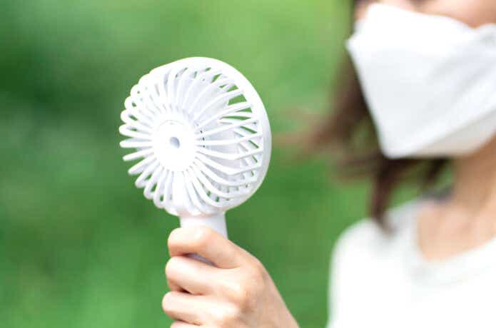 ハンディ扇風機を使用する女性