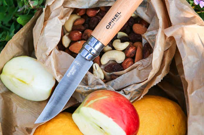 果物やナッツと中型のオピネルナイフ