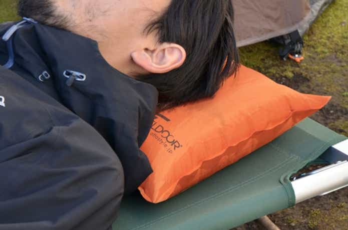 キャンプ枕を使用する男性