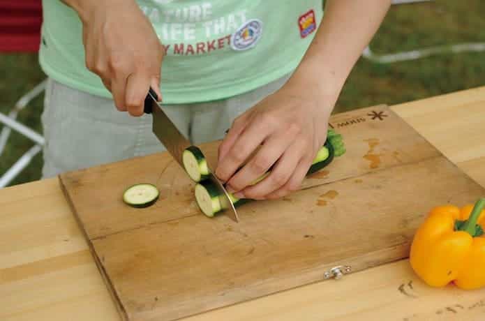 ナイフとまな板のセットを使って野菜を切っている